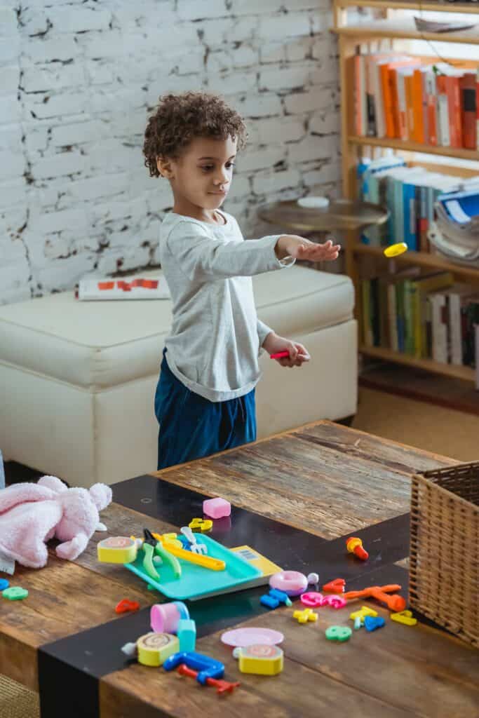 Child playing with toys on the coffee table in lounge room. 