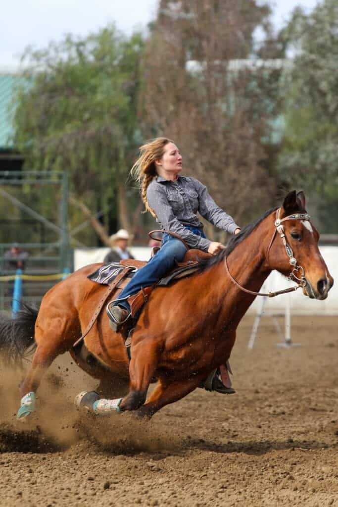 women riding horse in rodeo