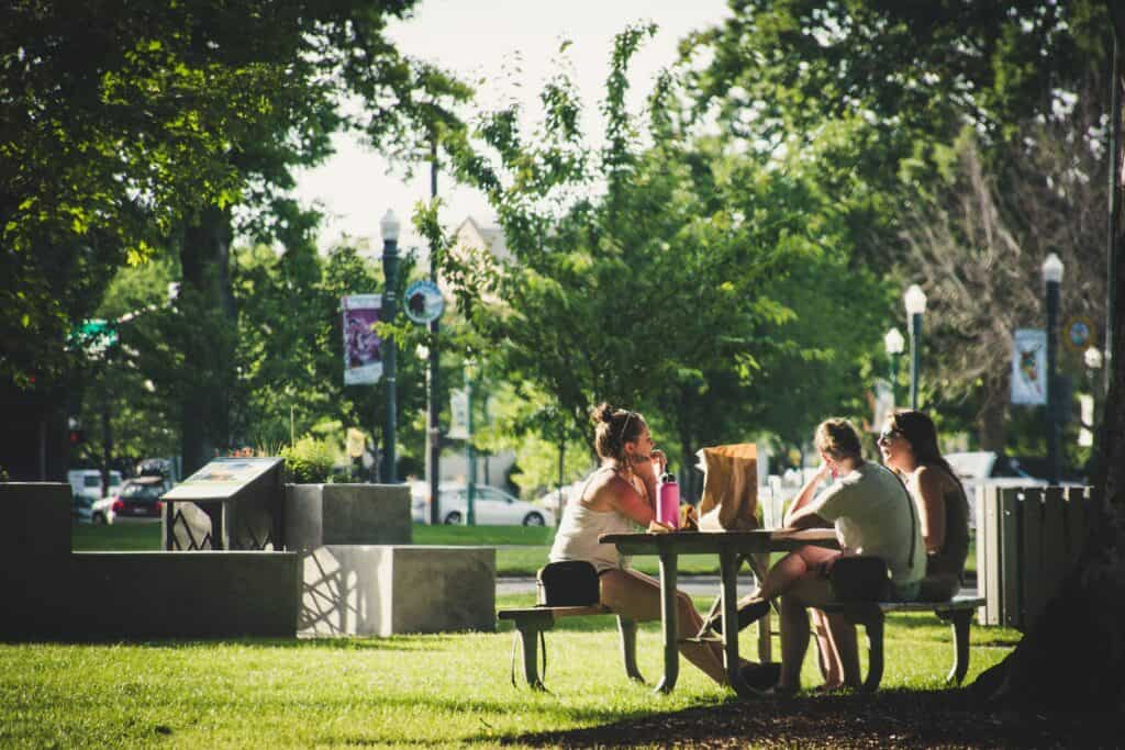 group of friends eating lunch at a park