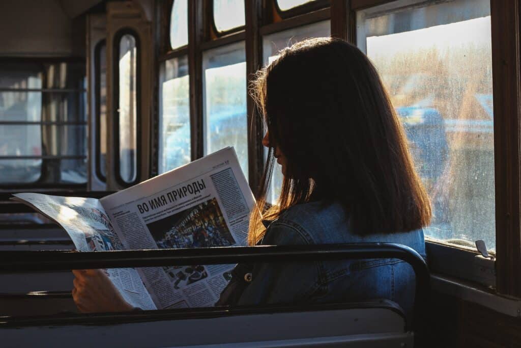 woman reading newspaper on the bus